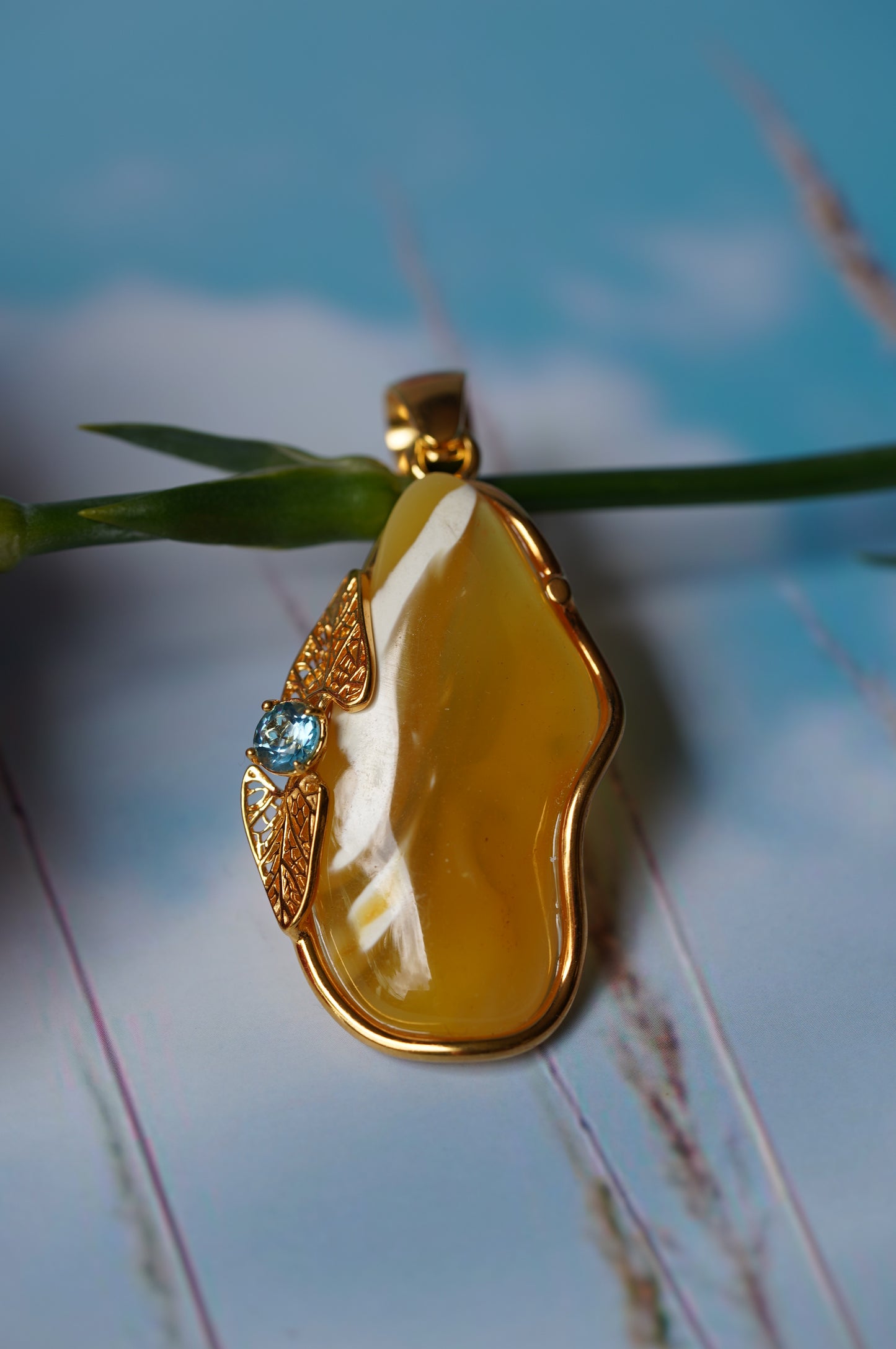 Natural Irregular Honey / Royal White Amber Pendant in Gold Plated Silver Frame with Blue Topaz