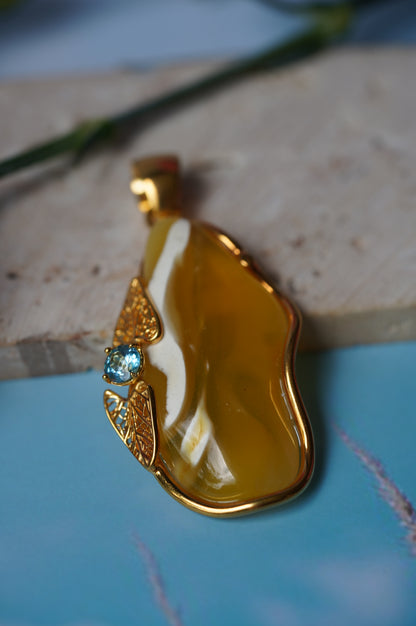 Natural Irregular Honey / Royal White Amber Pendant in Gold Plated Silver Frame with Blue Topaz