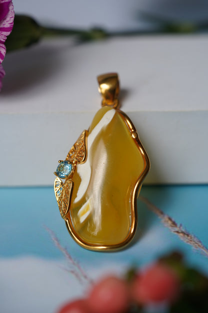 Natural Irregular Honey / Royal White Amber Pendant in Gold Plated Silver Frame with Blue Topaz