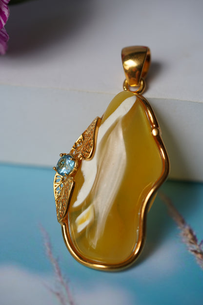 Natural Irregular Honey / Royal White Amber Pendant in Gold Plated Silver Frame with Blue Topaz